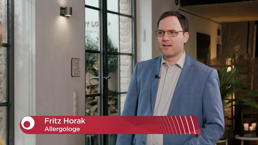 Allergologe Fritz Horak steht im Studio im Rahmen eines Interviews. Sein Name und Beruf werden unten im Bild eingeblendet.