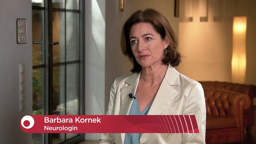 Barbara Kornek steht im Studio beim Interview, eingeblendet ist eine Bauchbinde mit ihrem Namen und der Berufsbezeichnung „Neurologin“.