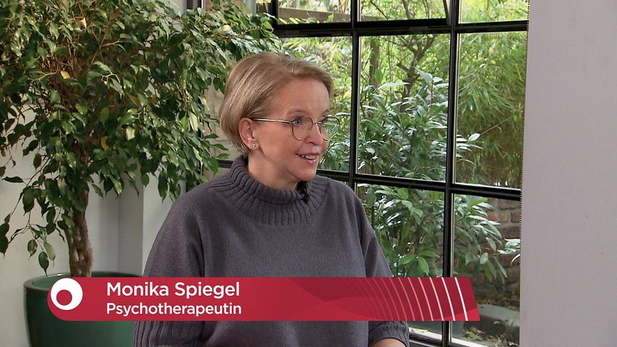 Dr. Monika Spiegel gibt ein Interview in einem hellen Studio mit großen Fenstern.