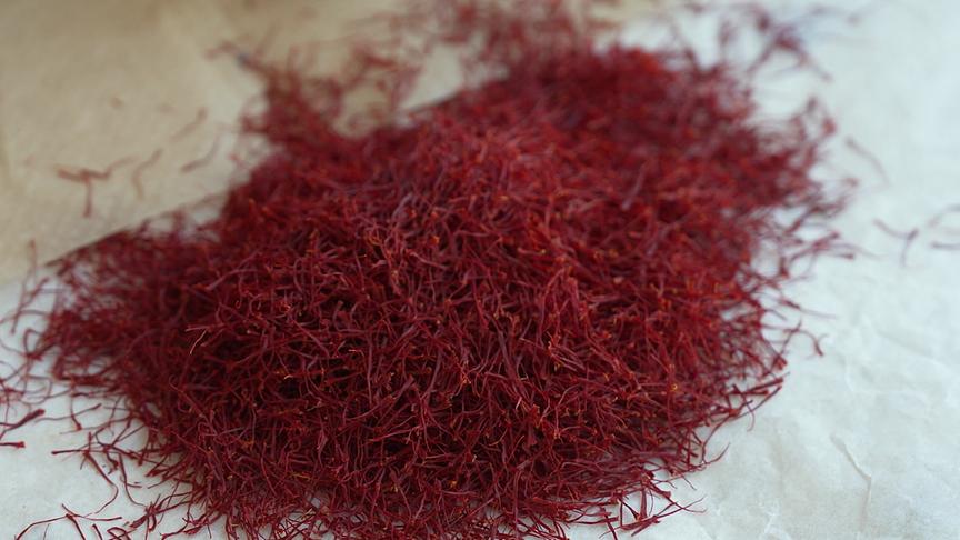 Ein Haufen getrockneter, tiefroter Safranfäden auf hellem Untergrund