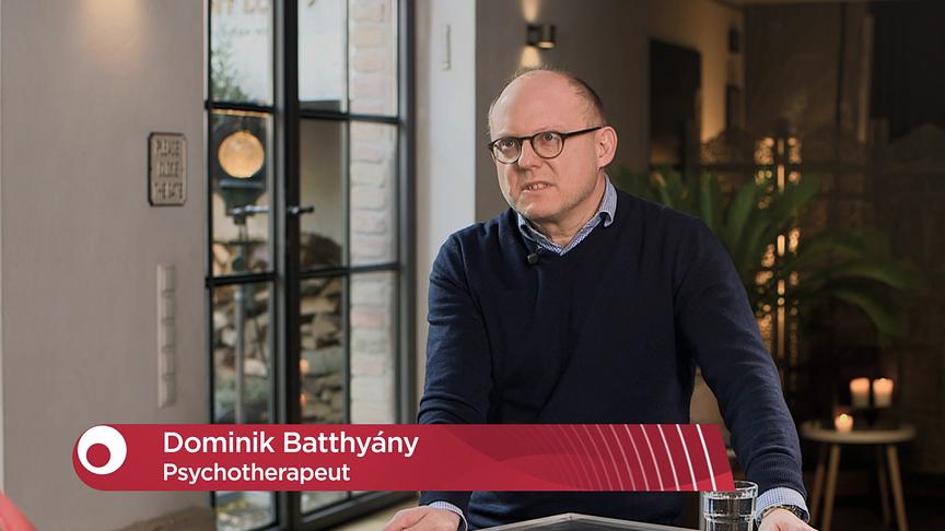 Dr. Dominik Batthyány, Psychotherapeut und Leiter des Vereins ERGON, beim  Interview in einem hell eingerichteten Raum mit Pflanzen und großen Fenstern.