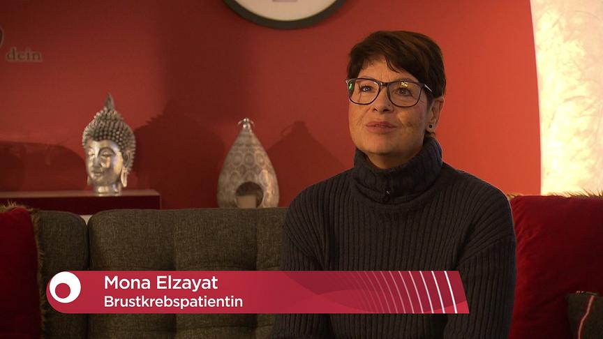 Mona Elzayat, Brustkrebspatientin, sitzt in wohnlicher Umgebung bei einem Fernsehinterview