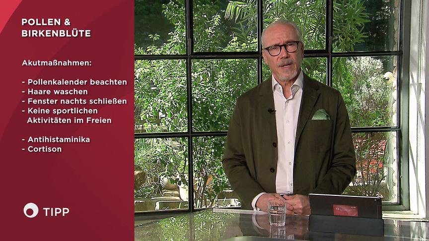 Prof. Dr. Siegfried Meryn steht an einem Tisch im Studio und erklärt Akutmaßnahmen bei Pollen & Birkenblüten, die grafisch links eingeblendet sind.