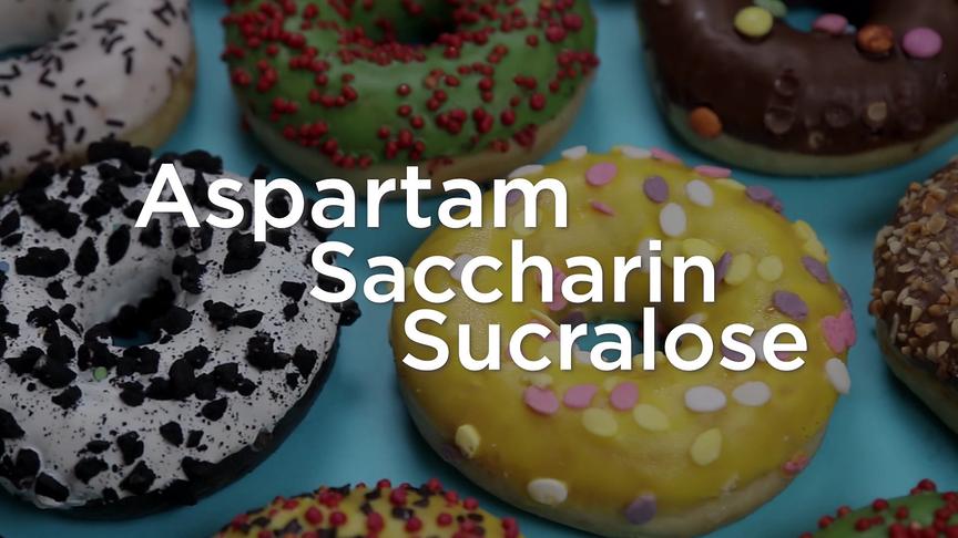 Bunte Donuts dienen als Hintergrund für die Begriffe Aspartam, Saccharin und Sucralose.