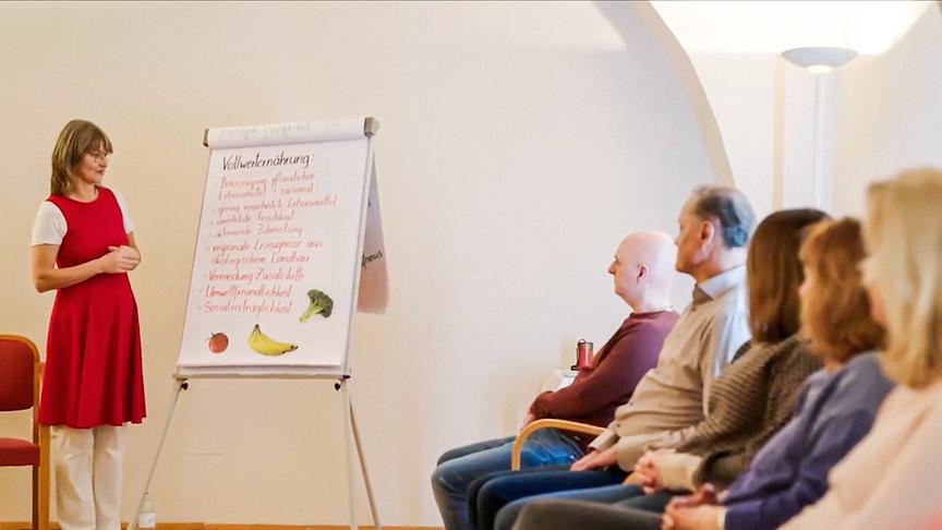 Fastenbegleiterin Andrea Loew bei einem Vortrag vor Teilnehmer:innen in Pernegg, unterstützt von einem Flipchart.